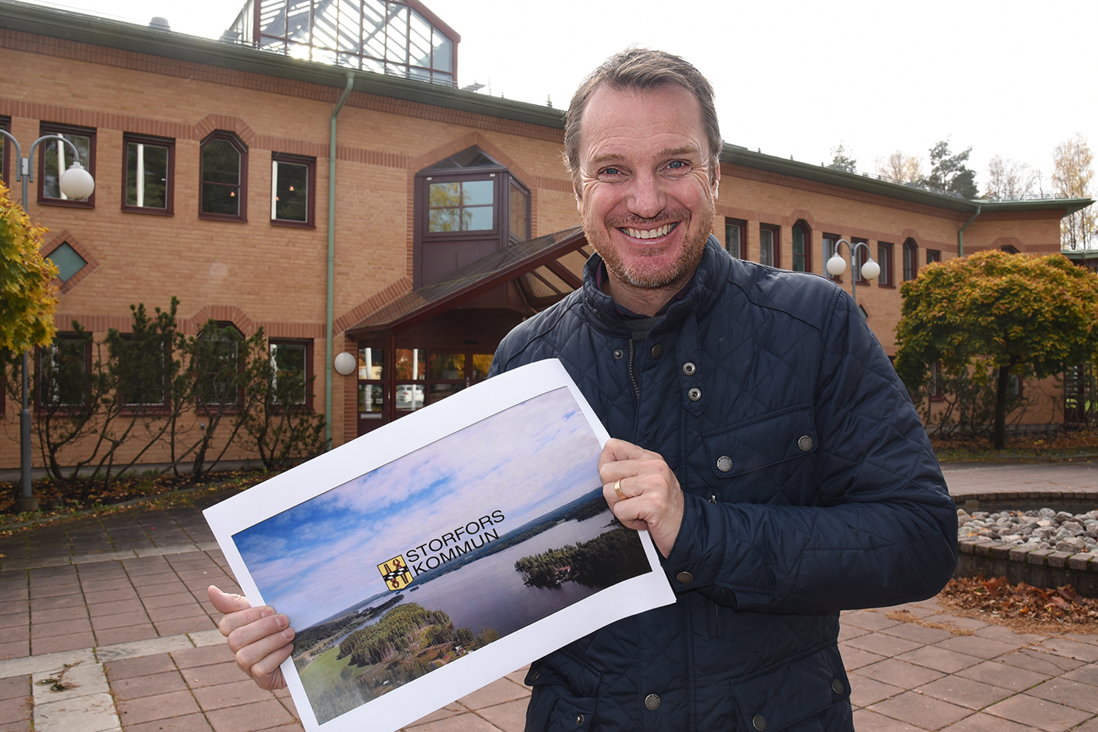 Bild på en glad kommunchef, Mats Öhman, som håller i en bild som visar den nya filmen.