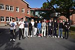 Niondeklassare i Storfors står på skolgården med krattor i högsta hugg